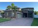 Beautiful two-story home with stone accents, a brick driveway, and lush tropical landscaping at 3159 Somerset Park Dr, Orlando, FL 32824