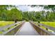 Scenic bridge with wooden railing overlooking a serene, green landscape with trees and grassy areas, offering a peaceful ambiance at 3349 Schoolhouse Rd, Harmony, FL 34773