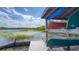 Wooden dock with canoes racked underneath a covered structure, overlooking a serene lake with lush vegetation at 3349 Schoolhouse Rd, Harmony, FL 34773