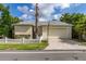 Inviting home featuring a well-manicured lawn, white picket fence, and a convenient two-car garage at 3349 Schoolhouse Rd, Harmony, FL 34773