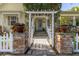 Trellised entryway with brick columns and stone walkway leads to front door at 3349 Schoolhouse Rd, Harmony, FL 34773