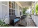 Inviting front porch with brick flooring and comfortable wicker seating area, perfect for relaxing outdoors at 3349 Schoolhouse Rd, Harmony, FL 34773
