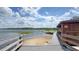 Scenic lakeside view with a wooden dock and boat storage, offering recreational opportunities and waterfront access at 3349 Schoolhouse Rd, Harmony, FL 34773
