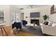 Comfortable living room with ceiling fan, hardwood floors, blue accent chairs, and a cozy fireplace at 3349 Schoolhouse Rd, Harmony, FL 34773