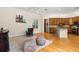 Open living space showcasing hardwood floors, dark fireplace, ceiling fan and kitchen in the background at 3349 Schoolhouse Rd, Harmony, FL 34773