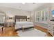 Cozy main bedroom showcasing hardwood floors, a plush bed, and bright natural light from the windows at 3349 Schoolhouse Rd, Harmony, FL 34773