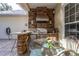 An inviting outdoor kitchen boasts a built-in grill, stone accents, and ample counter space for entertaining at 3349 Schoolhouse Rd, Harmony, FL 34773