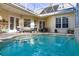 Enclosed patio area featuring a sparkling swimming pool, outdoor kitchen, and comfortable seating for entertaining at 3349 Schoolhouse Rd, Harmony, FL 34773