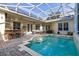 Enclosed patio area featuring a sparkling swimming pool, outdoor kitchen, and comfortable seating for entertaining at 3349 Schoolhouse Rd, Harmony, FL 34773