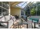 Enclosed patio area with brick pavers, comfortable seating, and a refreshing swimming pool with lush, tropical landscaping at 3349 Schoolhouse Rd, Harmony, FL 34773