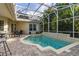 Inviting enclosed pool area with brick pavers and lush tropical landscaping, perfect for relaxation and outdoor enjoyment at 3349 Schoolhouse Rd, Harmony, FL 34773
