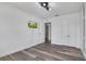A well-lit bedroom with wood-look floors, a TV, and convenient access to an en-suite bathroom and closet at 3400 Mt Vernon Way, Kissimmee, FL 34741