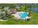 Resort-style pool area with tiled roof clubhouse and seating, overlooking a beautiful lake at 3400 Mt Vernon Way, Kissimmee, FL 34741