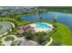 Resort-style pool area with tiled roof clubhouse and seating, overlooking a beautiful lake at 3400 Mt Vernon Way, Kissimmee, FL 34741