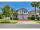 Two-story home with a brick driveway, two-car garage, manicured lawn, and lush landscaping at 3400 Mt Vernon Way, Kissimmee, FL 34741