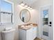 Bright bathroom features a vanity with a gold mirror and a walk-in shower at 344 High Point Dr, Davenport, FL 33837