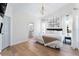 Bright bedroom features a chandelier, wood flooring, and a king bed with ensuite bathroom at 344 High Point Dr, Davenport, FL 33837