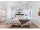 Bedroom features a chandelier, wood flooring, and a king bed with ensuite bathroom at 344 High Point Dr, Davenport, FL 33837