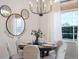 Dining area with table set for six under a modern chandelier, and decorative Mickey Mouse mirrors at 344 High Point Dr, Davenport, FL 33837