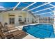 Swimming pool with outdoor lounge area and sunny screened lanai at 344 High Point Dr, Davenport, FL 33837