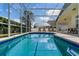 Sparkling pool surrounded by a screened enclosure and a sunny outdoor living area at 344 High Point Dr, Davenport, FL 33837