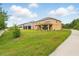 View of the house from the backyard, showing the covered patio and spacious lawn at 3899 Mount Vernon Way, Kissimmee, FL 34741