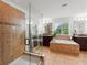 Stylish bathroom features a tiled glass shower, soaking tub, and double vanity sinks at 3899 Mount Vernon Way, Kissimmee, FL 34741