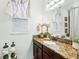 Bathroom featuring a granite vanity with an undermount sink and decorative floral arrangements at 3899 Mount Vernon Way, Kissimmee, FL 34741