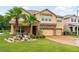 Charming tan two-story home featuring a brick-paved driveway, manicured lawn, and a spacious three-car garage at 3899 Mount Vernon Way, Kissimmee, FL 34741