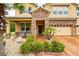 Inviting front entrance with stone accents, two rocking chairs, and landscaped garden at 3899 Mount Vernon Way, Kissimmee, FL 34741