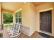 Inviting front entrance featuring two rocking chairs on a brick-paved porch with stone accents at 3899 Mount Vernon Way, Kissimmee, FL 34741