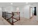 Bright hallway featuring a decorative wood railing and neutral carpeting at 3899 Mount Vernon Way, Kissimmee, FL 34741