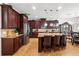 Gourmet kitchen features a large island, granite countertops, stainless steel appliances, and dark wood cabinets at 3899 Mount Vernon Way, Kissimmee, FL 34741