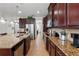 Galley kitchen features stainless steel appliances, granite countertops, and rich dark wood cabinetry at 3899 Mount Vernon Way, Kissimmee, FL 34741