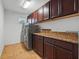 Laundry room with granite countertops and front load washer and dryer at 3899 Mount Vernon Way, Kissimmee, FL 34741