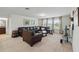 Spacious living room featuring dark leather furniture, carpet flooring, and abundant natural light at 3899 Mount Vernon Way, Kissimmee, FL 34741