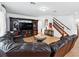 Cozy living room with a leather sofa, entertainment center and staircase at 3899 Mount Vernon Way, Kissimmee, FL 34741