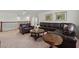Spacious living room featuring leather furniture, neutral carpeting, and decorative artwork at 3899 Mount Vernon Way, Kissimmee, FL 34741