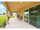 Inviting covered patio with an outdoor seating area and view of the spacious backyard at 3899 Mount Vernon Way, Kissimmee, FL 34741