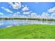 Scenic pond view with a fountain and surrounding lush green grass with community homes around the pond at 3899 Mount Vernon Way, Kissimmee, FL 34741