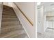 Carpeted staircase with a wooden handrail leading upstairs, kitchen is visible at 411 Sheoah Blvd # 33, Winter Springs, FL 32708