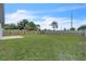 Large backyard with a mix of wood and concrete fencing, a grassy lawn, and mature trees at 5627 Marvell Ave, Orlando, FL 32839