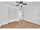 Bedroom featuring wood-look floors, a closet with louvered doors, and a ceiling fan at 5627 Marvell Ave, Orlando, FL 32839