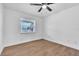 Bright bedroom featuring a ceiling fan, wood-look floors, and a window with natural light at 5627 Marvell Ave, Orlando, FL 32839