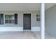 Welcoming front entrance with dark door, black shutters and a covered porch at 5627 Marvell Ave, Orlando, FL 32839