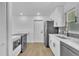 Bright kitchen features white cabinets, stainless steel appliances and a gray backsplash at 5627 Marvell Ave, Orlando, FL 32839