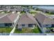 Aerial view of a home with backyard, screen lanai, storage shed, and lake in the background at 591 Lake Smart Blvd, Winter Haven, FL 33881