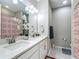 Bright bathroom featuring double sinks, quartz countertops, and a decorative shower curtain at 591 Lake Smart Blvd, Winter Haven, FL 33881