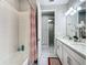 Bright bathroom featuring double sinks, quartz countertops, and a decorative shower curtain at 591 Lake Smart Blvd, Winter Haven, FL 33881