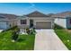 Inviting single-story home with a manicured lawn and long driveway leading to a two-car garage at 591 Lake Smart Blvd, Winter Haven, FL 33881
